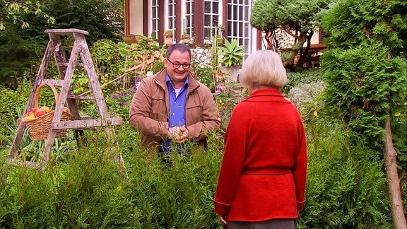 Mann und Frau in einem Garten im Gespräch 