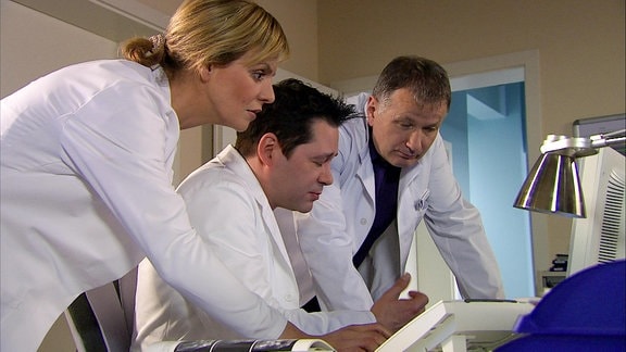 drei Ärzte beraten sich vor einem Computer