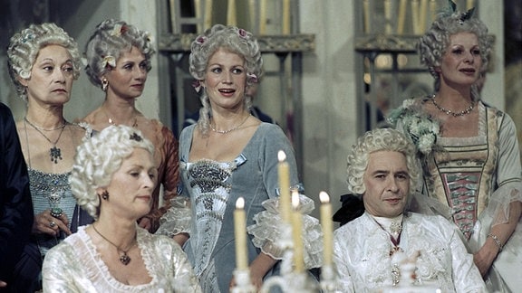 Irma Münch (Königin Maria Josepha) (li), Ezard Haußmann (Heinrich Graf von Brühl) (re) (sitzend, 1. Reihe), Marta Rafael (Gräfin Kolowrath, Oberhofmeisterin) (1.v.l.), Jitka Molavcova (Gräfin Franziska von Kolowrath) (3.v.l.) (2. Reihe stehend) 