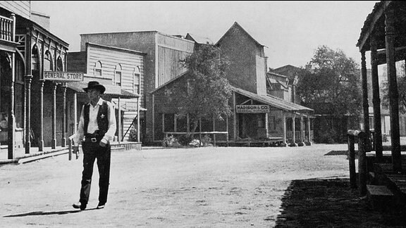 Marshall Will Kane auf einer Dorfstraße im Wilden Westen Ein Mann wartet am Bahnhof einer Westernstadt