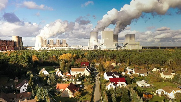 Ansicht Kohlekraftwerk mit Wohnsiedlung im Vordergrund