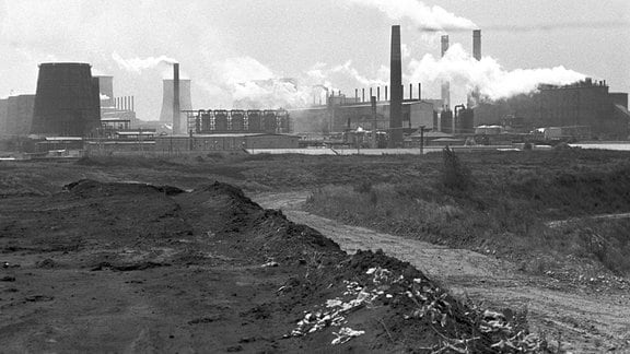 Aus den Schloten des Braunkohleveredlungswerkes Espenhain ziehen ätzende Staubwolken und Gasgerüche über das angrenzende Dorf Mölbis, aufgenommen im Sommer 1990