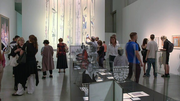 Blick in einen Ausstellungsraum mit vielen Besuchern.