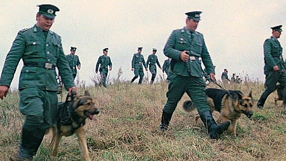 Volkspolizei Suchmannschaft mit Hunden in Suchkette.