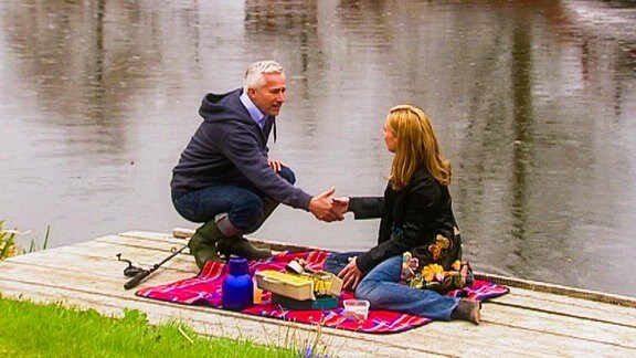 Frau und Mann bei Picknick an einem Kanal