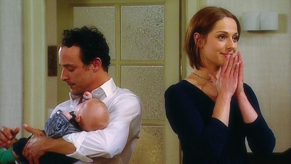 Eine Frau und ein Mann mit einem Baby auf dem Arm.