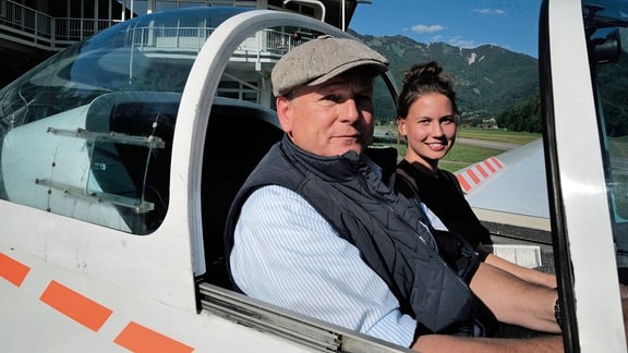 Mit Pilotin Katharina Hussel geht’s vom Gebirge hinüber Richtung Chiemsee. Axel Bulthaupt (li.)