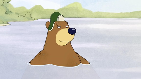 Ein Bär mit Mütze guckt aus einem See.