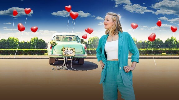 Meine Heimat - Im Auftrag der Liebe - Moderatorin Stephanie Müller-Spirra vor einem Hochzeitsauto mit Herzluftballons die in den Himmel aufsteigen