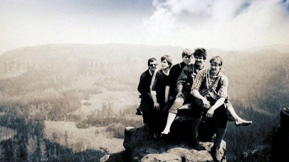Gruppe von Bergsteigern posiert auf einem Felsvorsprung.