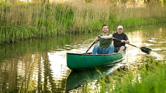 zwei Männer paddeln in einem Kanu auf einen Fluss
