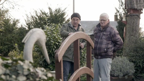 Zwei Männer unterhalten sich über die Gestaltung eines Gartens.