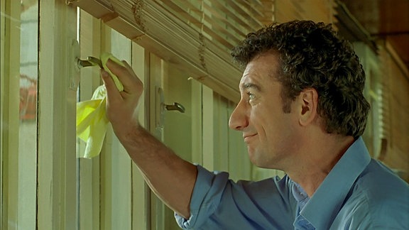 Ein Mann beim Putzen eines Fensters.