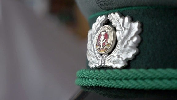 Emblem der DDR auf einer Mütze der Volkspolizei.