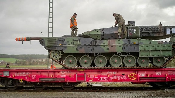 ein Panzer wird auf Zug verladen
