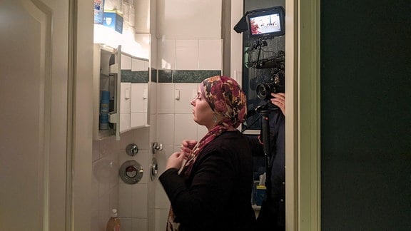 Karoline Roscher-Lagzouli legt während der Dreharbeiten ihr Kopftuch vor dem Spiegel an