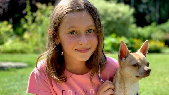 Ein Mädchen mit einem kleinen Hund.
