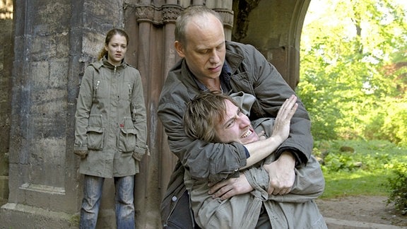 Hauptkommissar Kain (Bernd Michael Lade) überwältigt den entflohenen Häftling Michael Köster (Niels Bruno Schmidt) unter den Augen seiner Freundin Judith Wagner (Oona Devi Liebich) in den Morgenstunden im Park in Weimar.