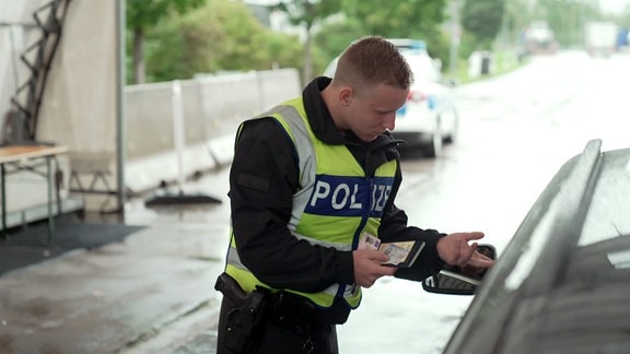 Polizist kontrolliert Autofahrer