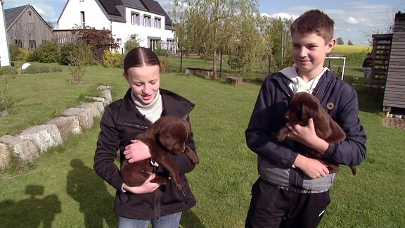 Mädchen und Junge mit Hundewelpen