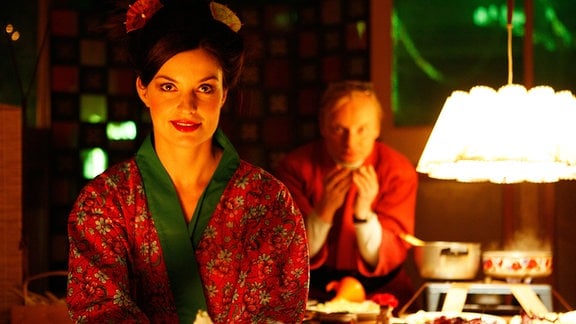 Szene aus dem Film "Sushi in Suhl": Geisha Giesela (Ina Paule Klink) und "Anschütz-San" (Uwe Steimle) bewirten stilecht ihre ersten Gäste.