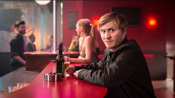 Junger Mann an der Bar in Nachtclub.
