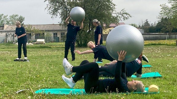 Die Frauen des Sportvereins Tornitz machen Übungen mit Bällen.