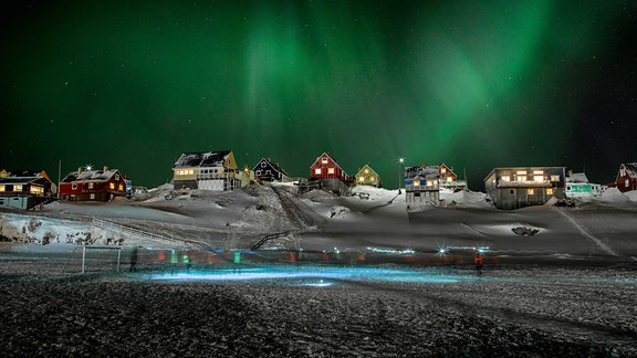 Polarlicht über Dorf auf Grönland. 