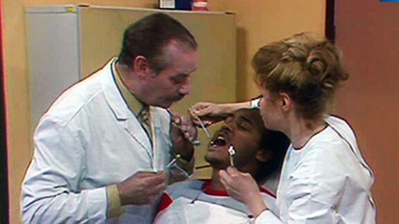 Dr. Wittkugel (Alfred Struwe) und Häppchen (Helga Piur) bei der Bahndlung eines Patienten.