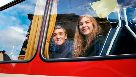 Alfons und Leonie beobachten die Jugendherberge aus dem Schulbusfenster.