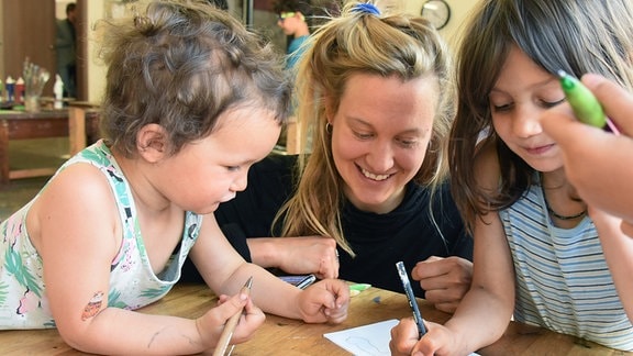 Kinder Laszlo (l) und Rala (r) mit Werkpädagogin Janina Werner 