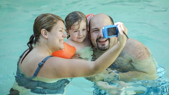Eine Familie macht ein Selfie im Schwimmbad