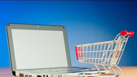 Ein Einkaufswagen steht auf der Tastatur eines Laptops.