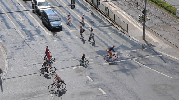 Fahrradfahrer fahren über eine Kreuzung.