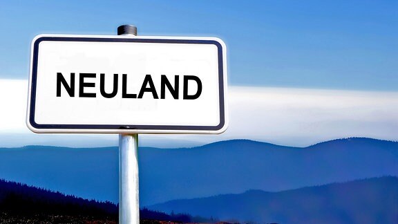 Ein Straßenschild mit der Aufschrift "Neuland" vor einem bergigen Hintergrund