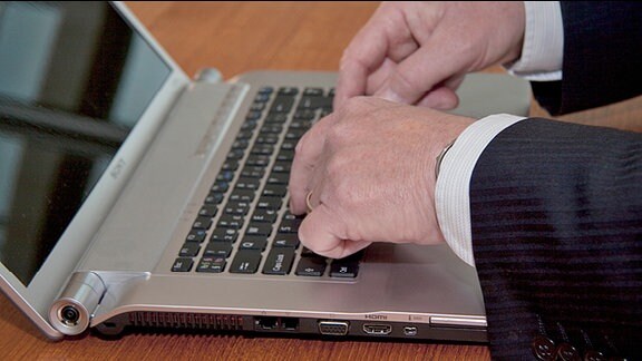 Zwei Hände auf der tastatur eines Laptops
