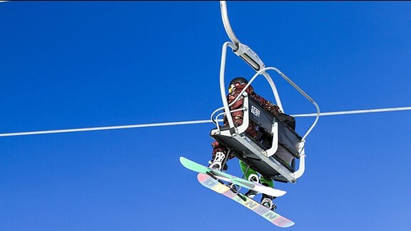 Zwei Snowboarder in Sessellift.
