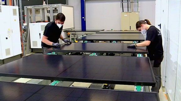 Mitarbeiter bei der Endkontrolle in der Solarzellenfertigung