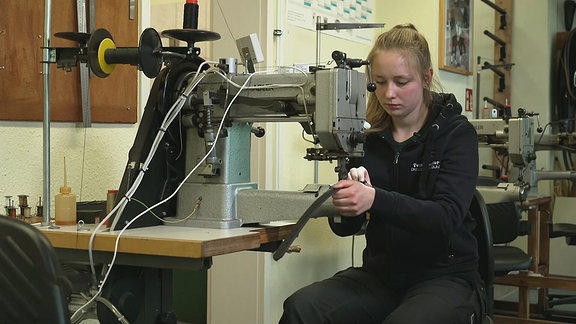 Eine junge Frau arbeitet an einer Maschine