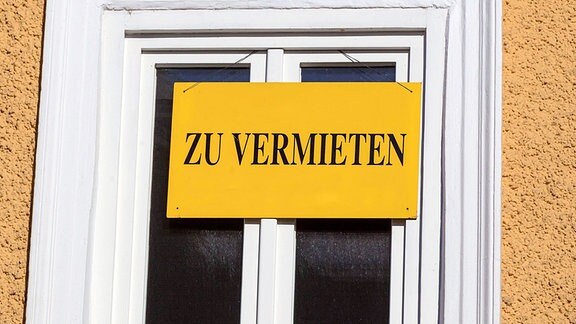 Ein Schild mit der Aufschrift "Zu vermieten" hängt an einem Fenster.