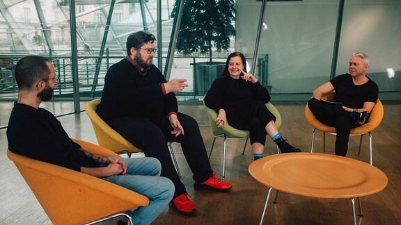 Die Filmkritiker*innen Frédéric Jaeger, Dennis Vetter und Dunja Bialas sitzen gemeinsam mit Markus Kavka an einem Tisch und unterhalten sich