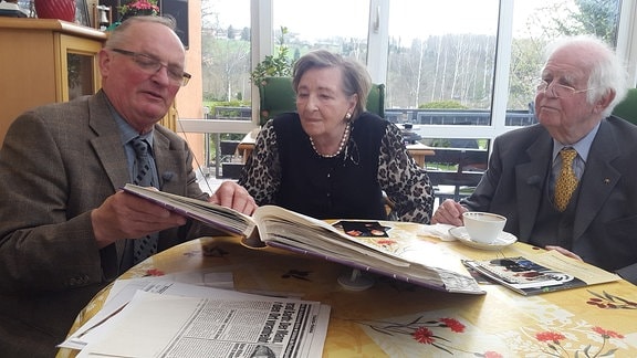 Konrad Barth, ehemaliger Bürgermeister von Schlema zeigt Ingrid und Kurt Biedenkopf alte Fotos.