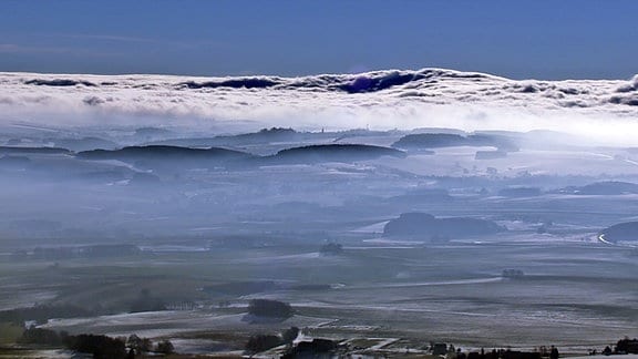 Ein Wolkenmeer erstreckt sich unterhalb der Hügel des Erzgebirges.