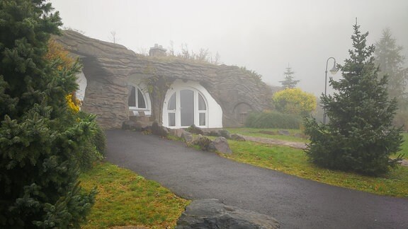 Erdhaus mit großem Fenster u. Terrassentür im Nebel