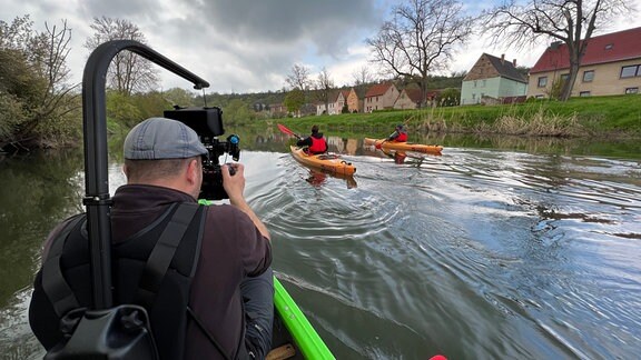Kameramann filmt zwei Männer beim Wasserwandern.
