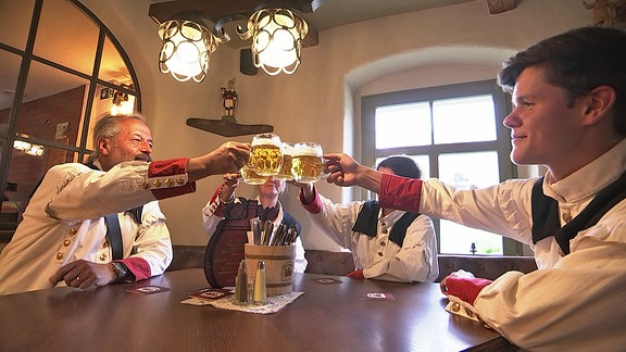 Männer und Frauen trinken Bier an einem Stammtisch in Olbernhau