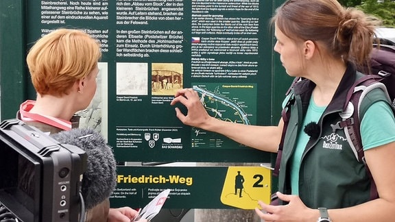 Neben der Stele in Krippen steht die erste von insgesamt elf sehr lehrreichen Informationstafeln. Kristin Arnold zeigt Beate Werner den Streckenverlauf des Caspar-David-Friedrich-Weges. 