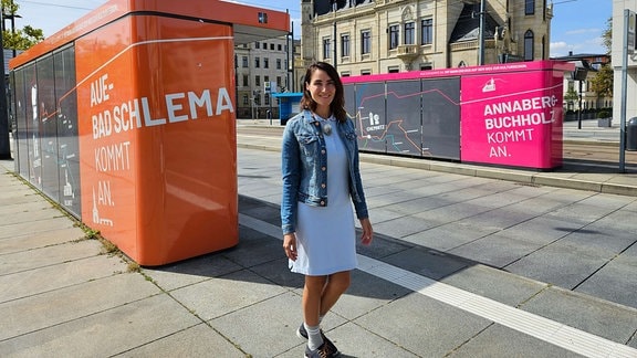 Eine junge Frau an einer Straßenbahnhaltestelle