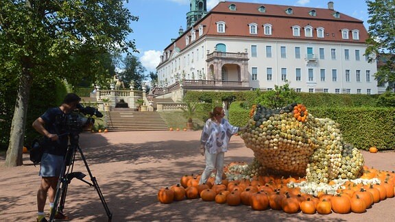 Eine junge Frau wird vor einem Schloss gefilmt