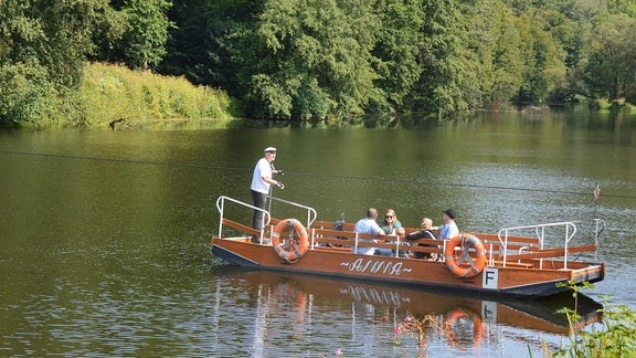 Menschen auf einer Fähre über einen See